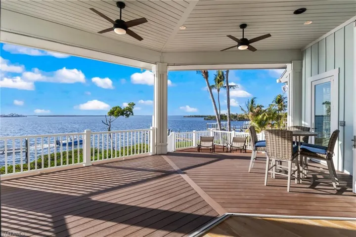 Upper deck off great room offers an incredible outdoor living space - a great way to spend the evenings - enjoy the dolphins and the sunsets!  There are electronic shade screens that make this space even more enjoyable!