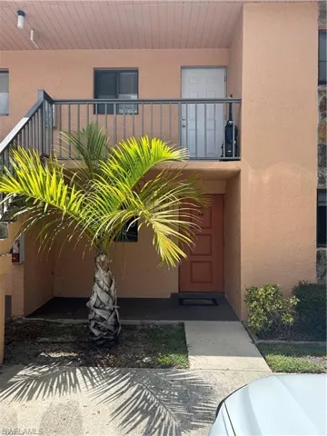 Doorway to property with stucco siding and a balcony