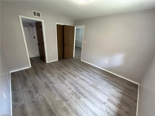 Unfurnished bedroom featuring wood finished floors and a closet