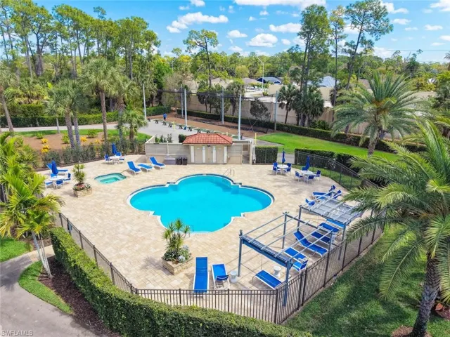 Community pool with a patio and a hot tub