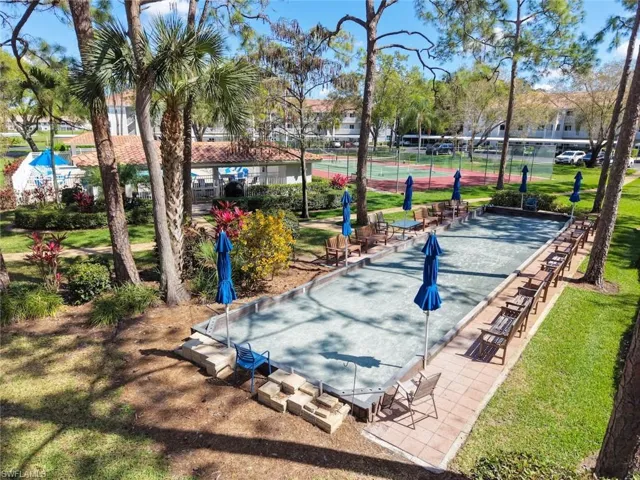 View of property's community with a game area, a patio, and a tennis court