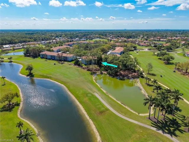Drone / aerial view of a golf course and a nearby body of water