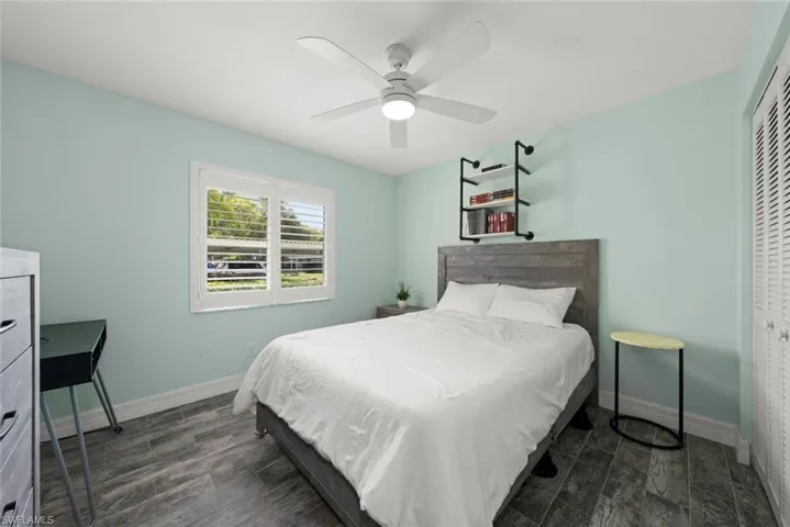 Bedroom with wood tiled floors, a closet, and ceiling fan