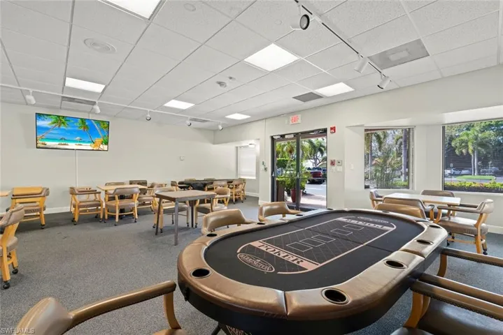 Recreation room with rail lighting and a paneled ceiling