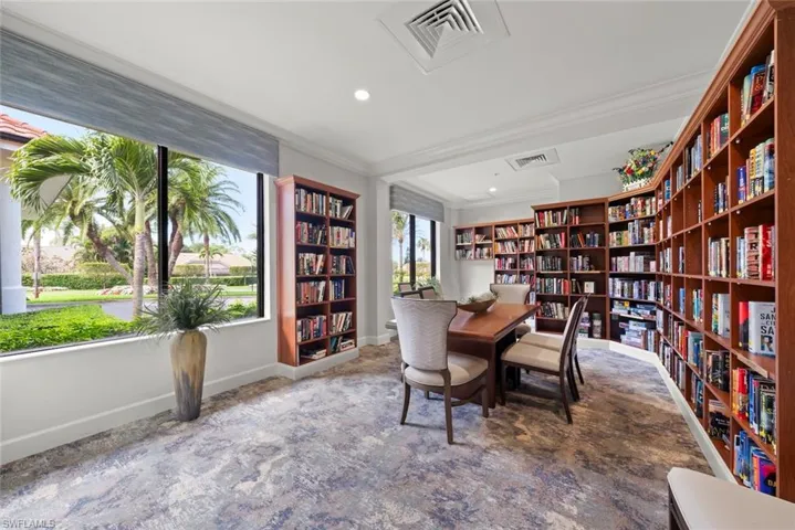 Office area with wall of books, ornamental molding, and recessed lighting
