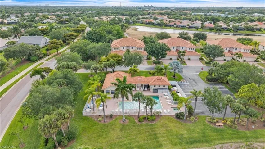 Community pool and clubhouse featuring a surrounding patio with lounge chairs