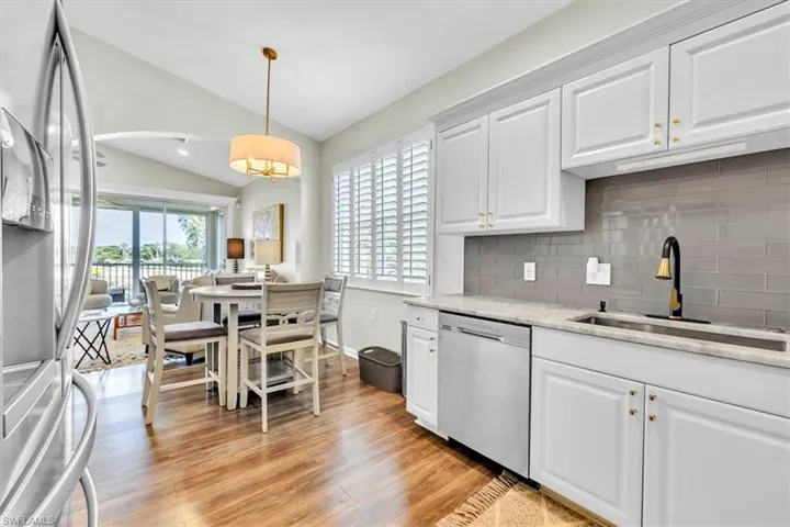 Kitchen featuring white shaker-style cabinetry, granite countertops, and a gray subway tile backsplash