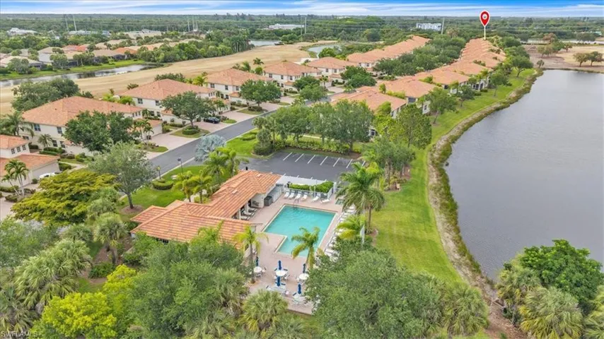 Aerial perspective showcasing a residential community with Mediterranean-inspired architecture featuring terra cotta tile roofs