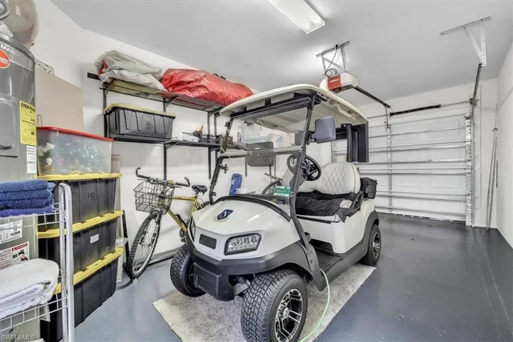 Garage interior featuring a sectional garage door, overhead lighting, and wall-mounted shelving