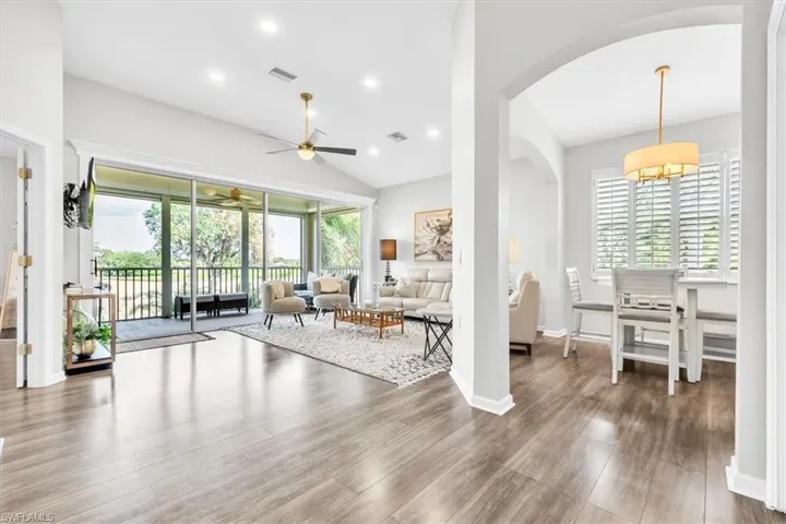 Open-concept interior featuring wood-finish flooring, vaulted ceilings, and recessed lighting