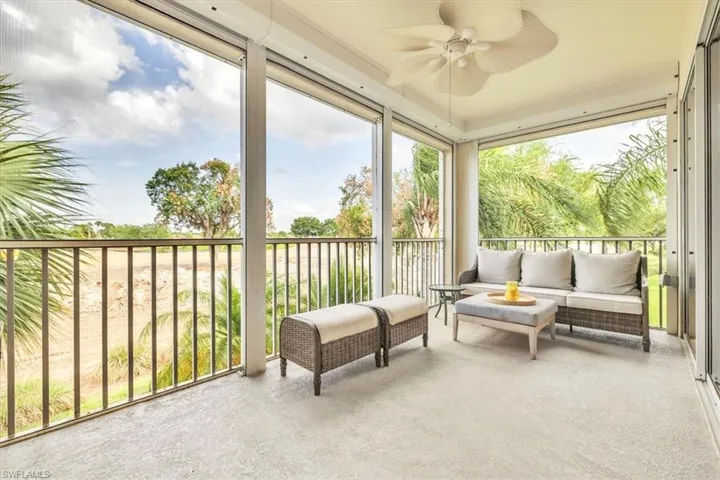 Screened lanai featuring a textured concrete floor and a ceiling fan