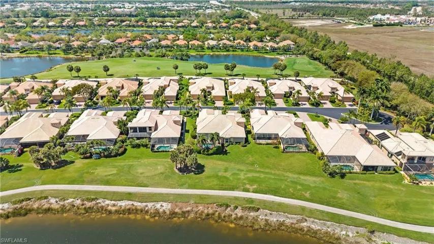 Aerial perspective of suburban area featuring a nearby body of water and a golf club