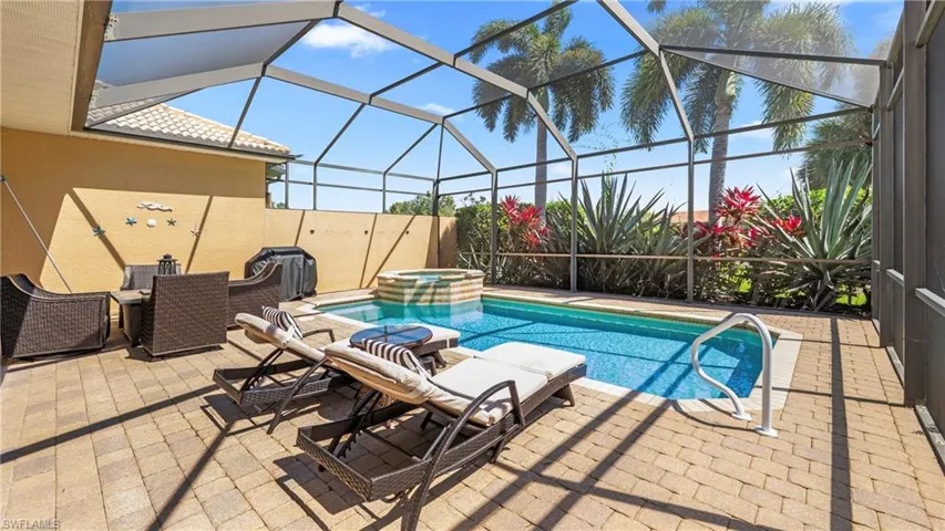 Integrated pool / hot tub with a sunroom, glass enclosure, and a patio