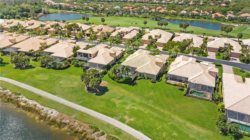 Aerial perspective of suburban area with a nearby body of water and a golf club