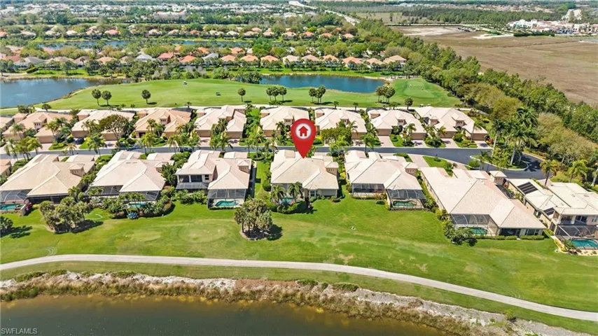 Aerial perspective of suburban area featuring a nearby body of water and a local golf course