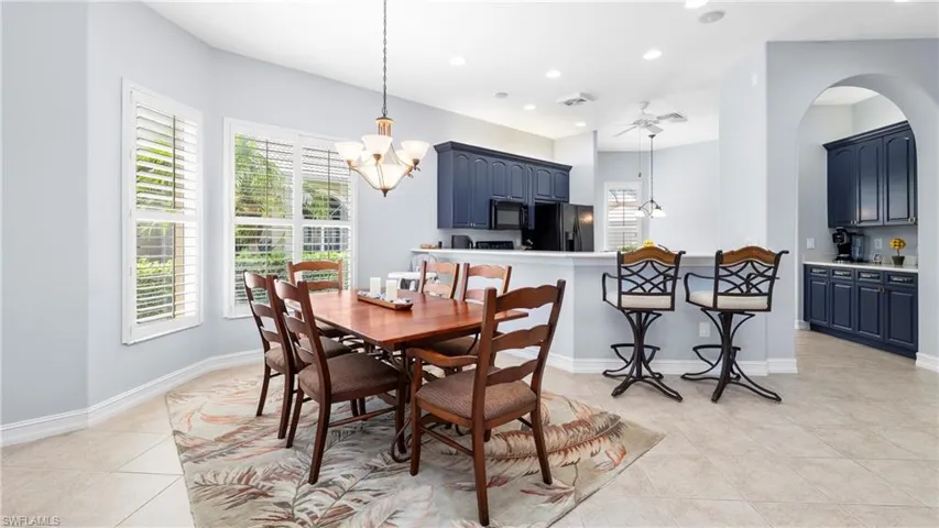 Dining space featuring light tile patterned floors, a chandelier, and a ceiling fan