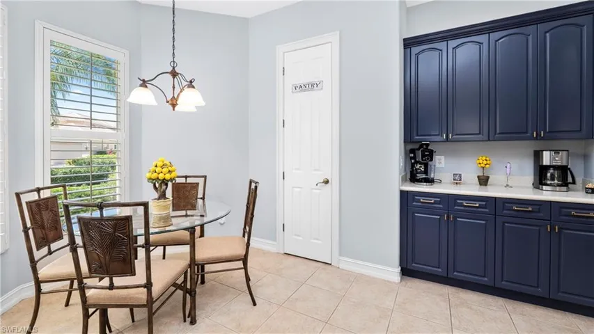 Dining room with light tile patterned floors and suspended lighting