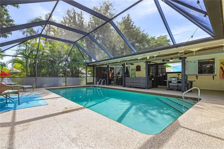 View of pool featuring a lanai, a patio area, and ceiling fan
