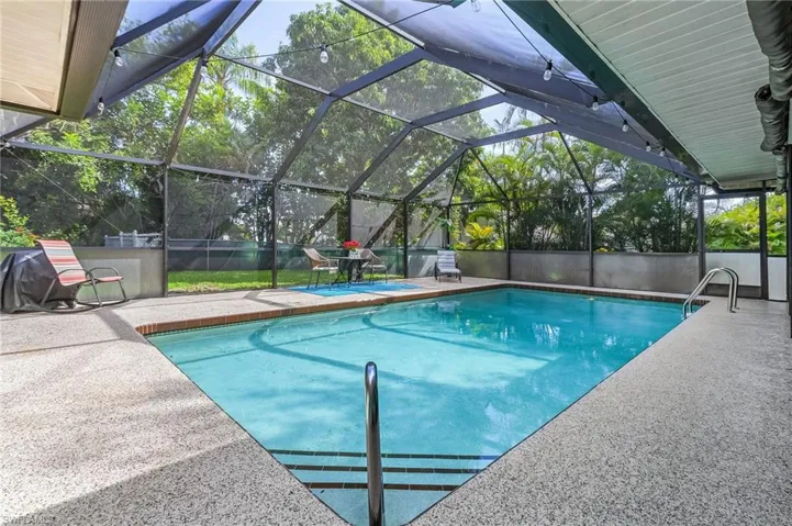 View of swimming pool featuring a patio and a lanai