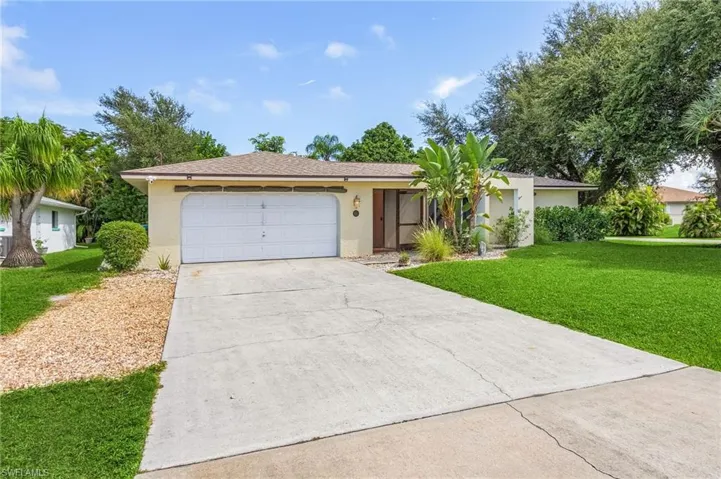 Single story home with a front yard and a garage