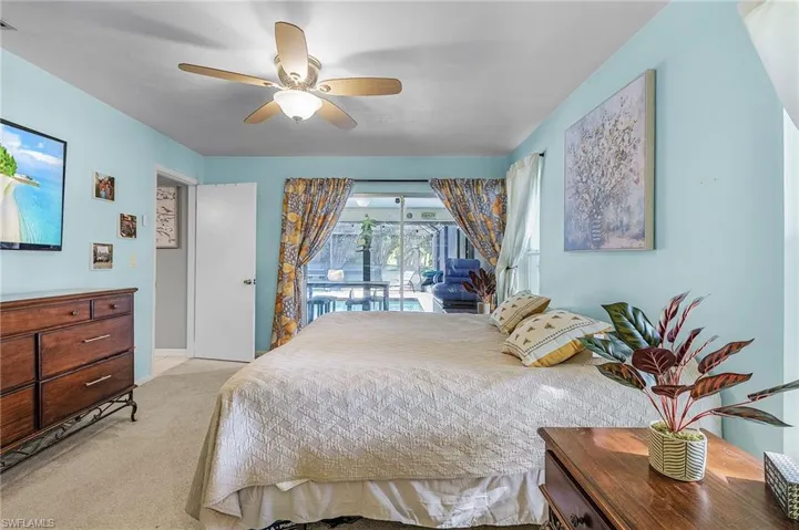 Carpeted bedroom featuring access to outside and ceiling fan