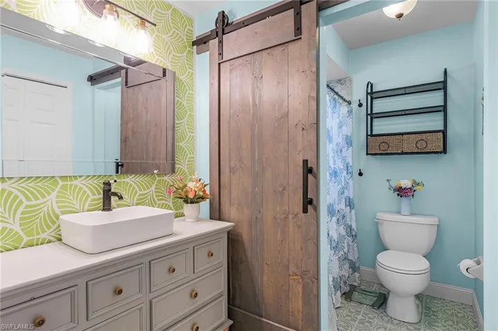 Bathroom featuring vanity, toilet, and tile patterned floors