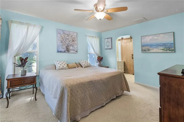 Bedroom with ceiling fan and light carpet