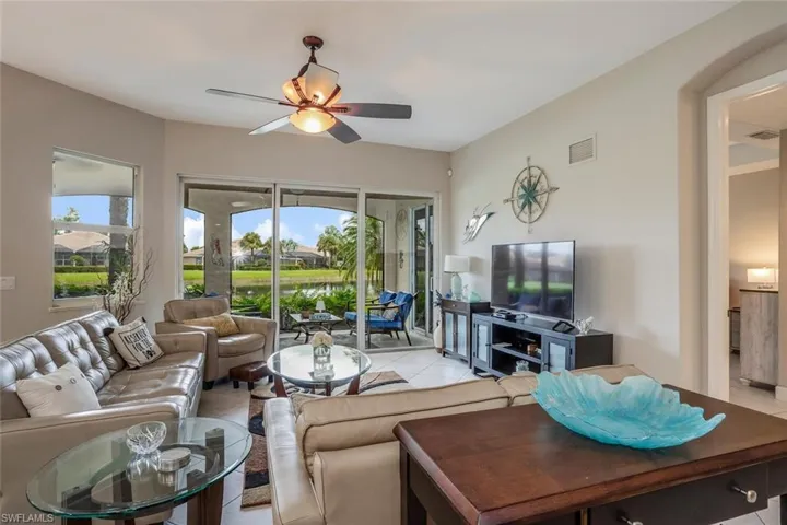 Tiled living area featuring ceiling fan and healthy amount of natural light