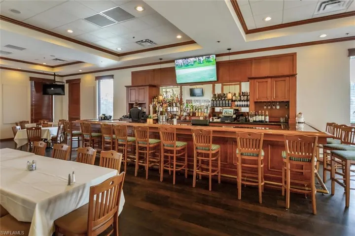 Dining area featuring a tray ceiling, crown molding, dark wood finished floors, and recessed lighting