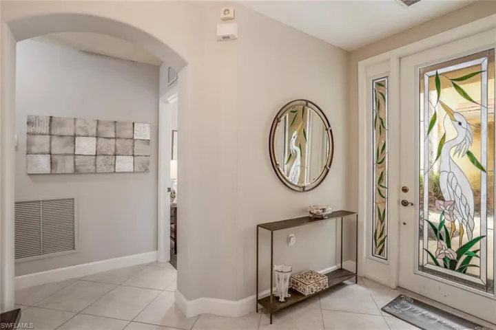 Foyer entrance featuring light tile patterned flooring and arched walkways