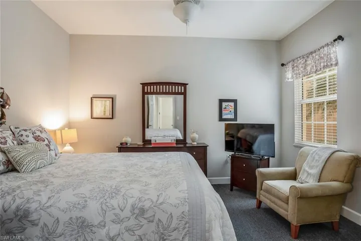 Bedroom featuring dark carpet and baseboards