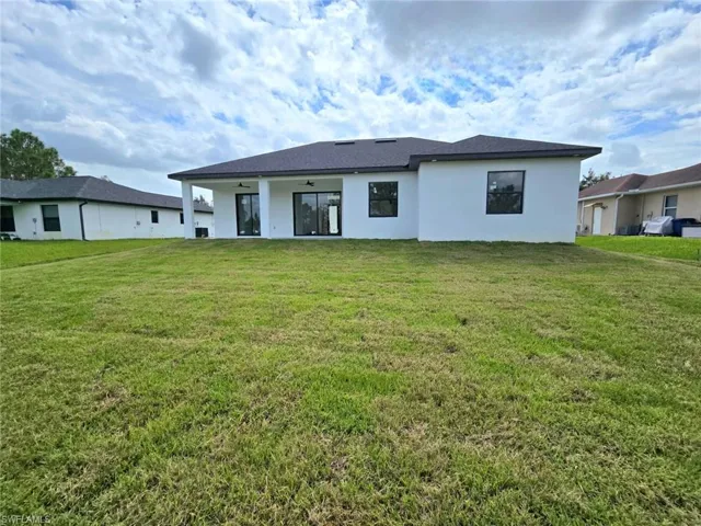 Rear view of house with a patio area and a yard