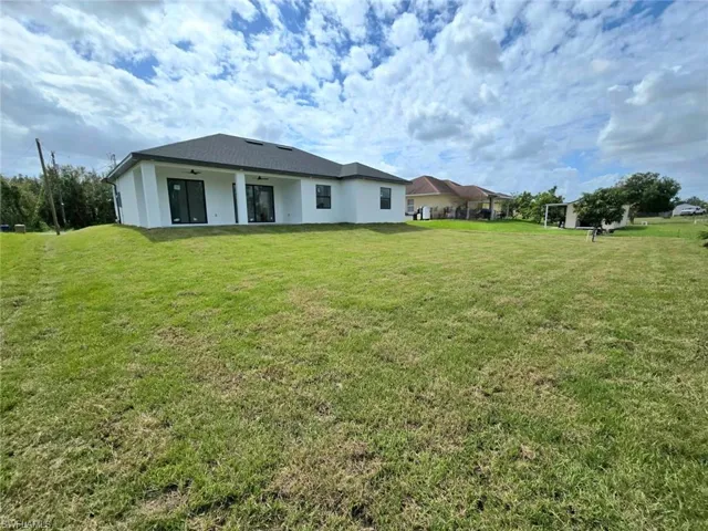 Rear view of property with a yard