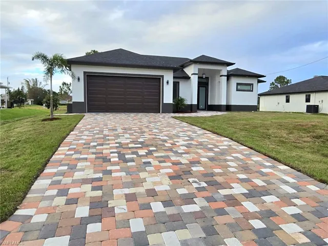 View of front of home featuring a front yard, a garage, and central air condition unit