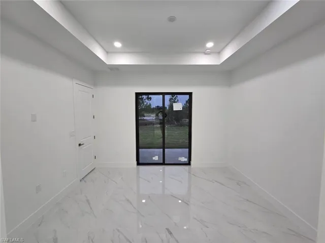 Unfurnished room with a raised ceiling