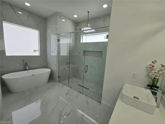 Bathroom with vanity and separate shower and tub