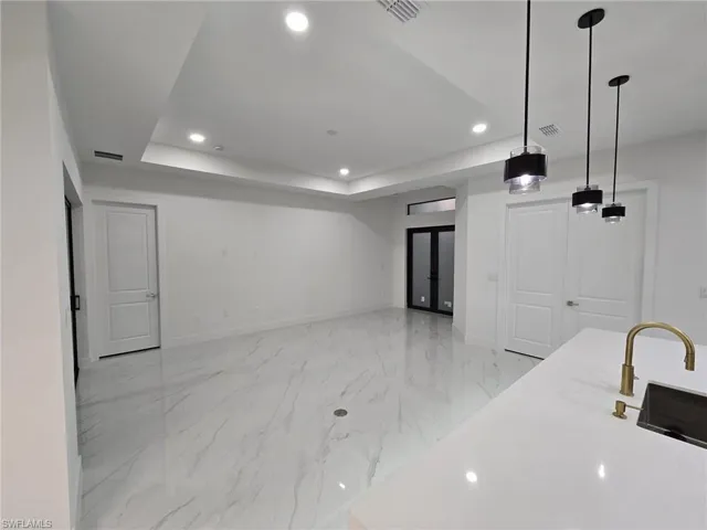 Kitchen with a tray ceiling and hanging light fixtures