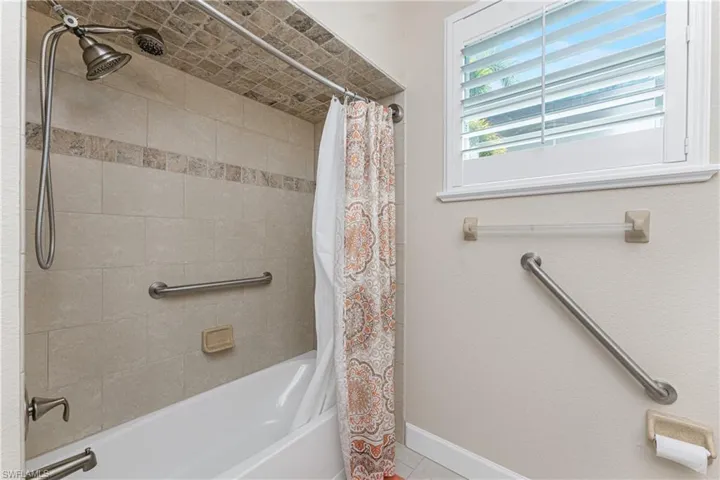 Bathroom with shower / bathtub combination with curtain