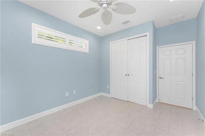 Unfurnished bedroom with ceiling fan, a closet, and light tile patterned floors