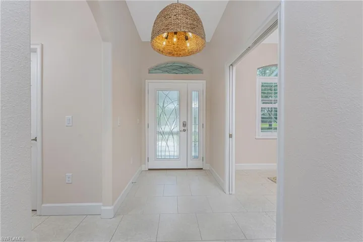 Entryway featuring lofted ceiling and light tile patterned floors