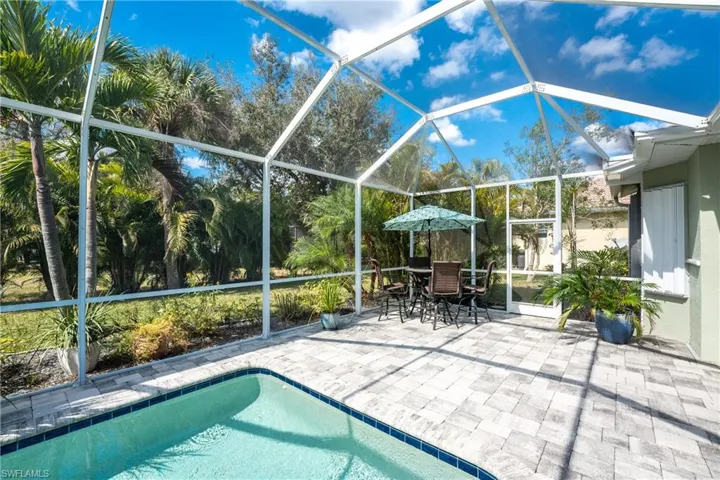 View of pool with glass enclosure and a patio area