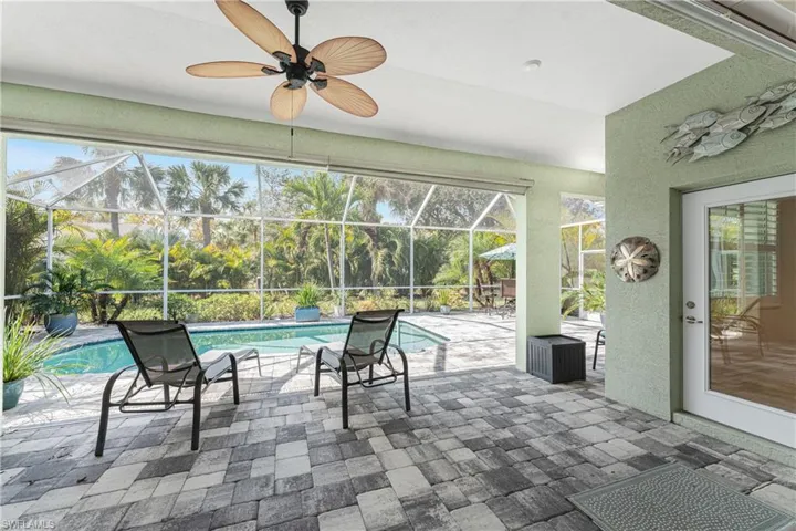 Sunroom featuring ceiling fan and a pool