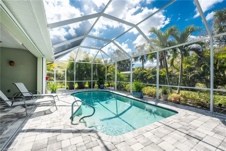 View of swimming pool with a patio area and glass enclosure