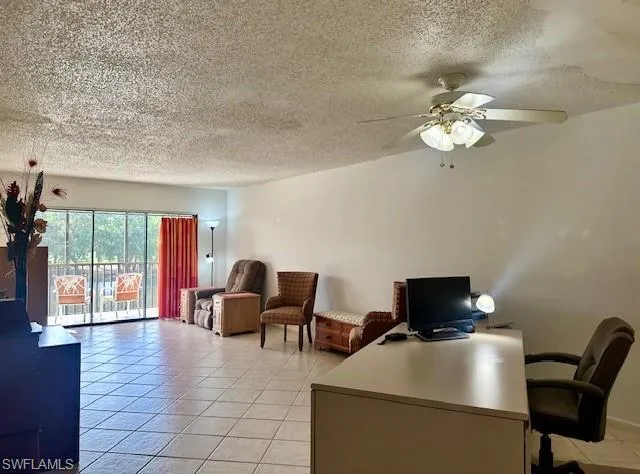 Tiled office featuring ceiling fan and a textured ceiling