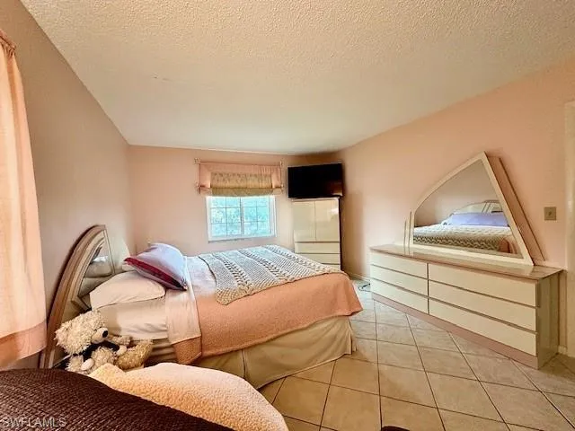 Tiled bedroom with a textured ceiling