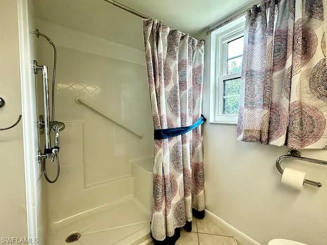 Bathroom featuring tile patterned flooring and curtained shower