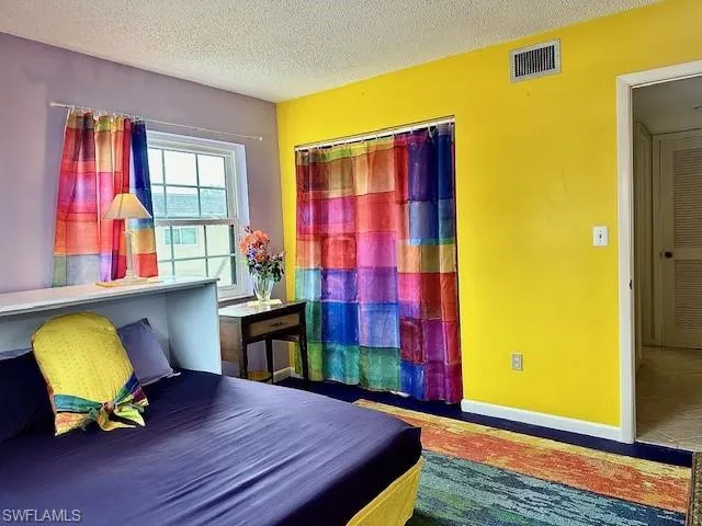 Bedroom with a textured ceiling and a closet