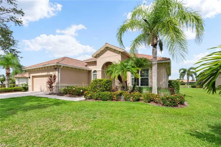 Mediterranean / spanish home featuring stucco siding, a front lawn, driveway, a garage, and a tile roof