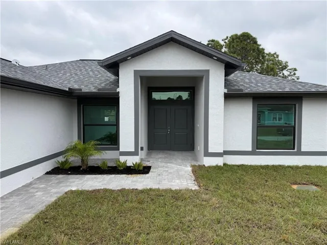 View of exterior entry featuring a lawn