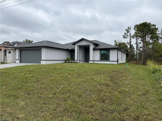 View of front of house featuring a garage and a front yard